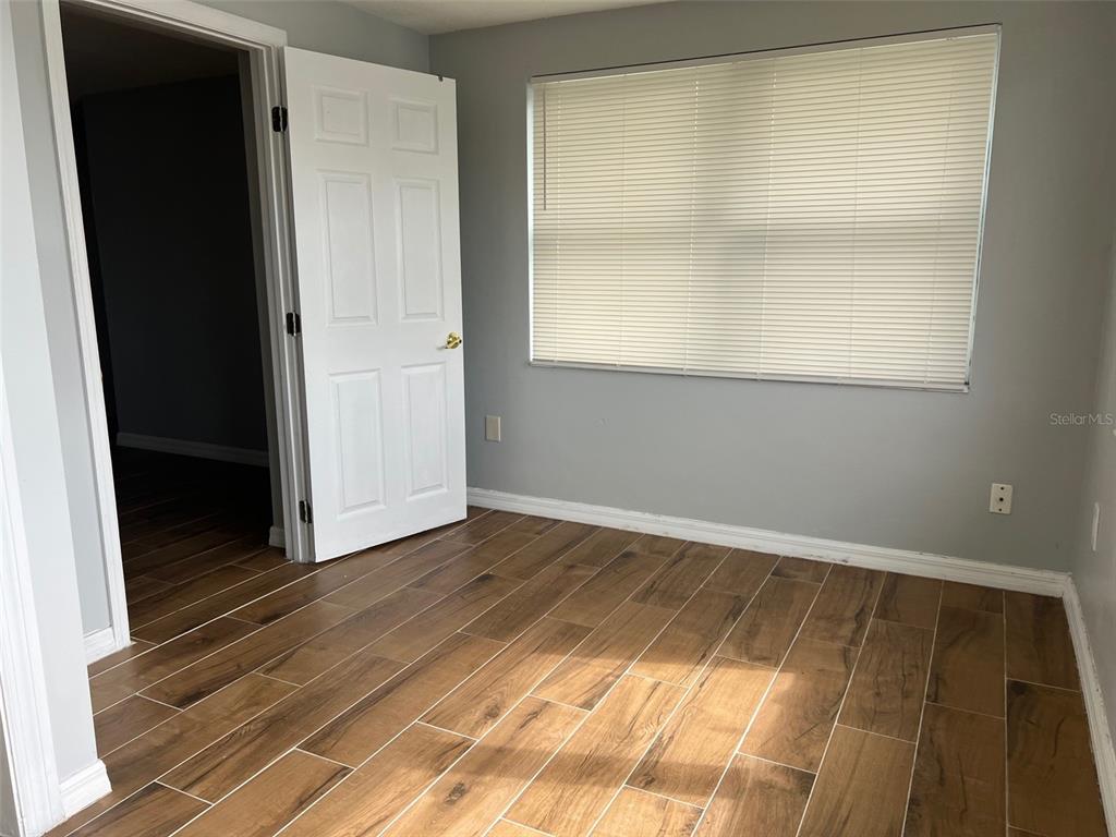 5046 Victoria Lane Holiday, FL 34690 - Photo 20 of 24 a view of an empty room with wooden floor and a window