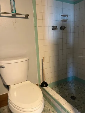 a white toilet sitting next to a shower