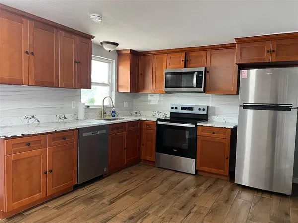 a kitchen with wooden cabinets and stainless steel appliances