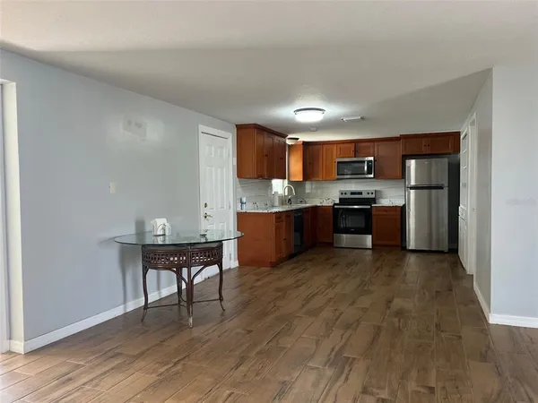 a view of kitchen with wooden floor and electronic appliances