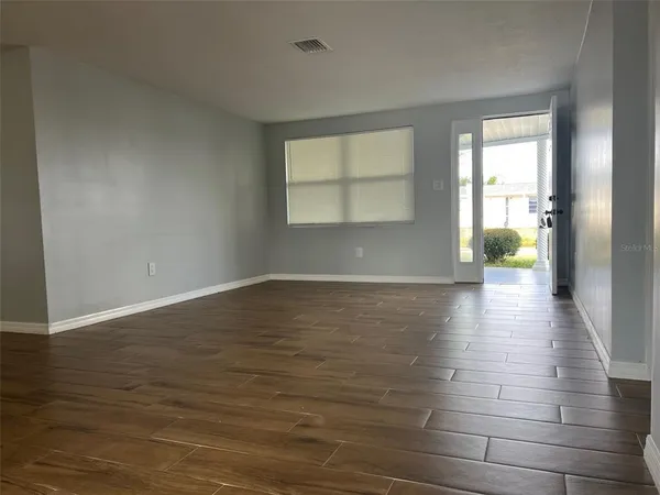 wooden floor in an empty room with a window
