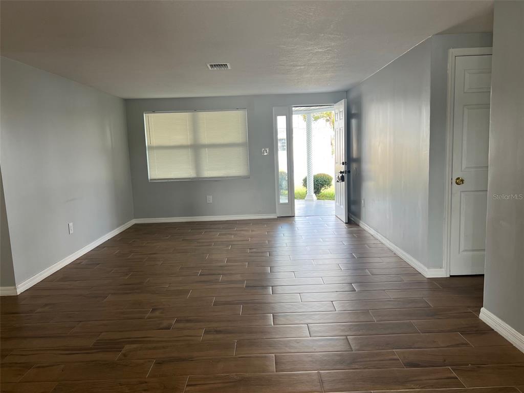 5046 Victoria Lane Holiday, FL 34690 - Photo 8 of 24 an empty room with wooden floor and windows