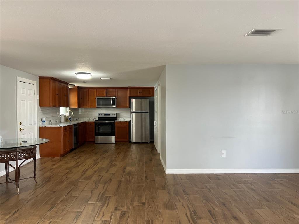 5046 Victoria Lane Holiday, FL 34690 - Photo 9 of 24 a large kitchen with cabinets wooden floor and stainless steel appliances