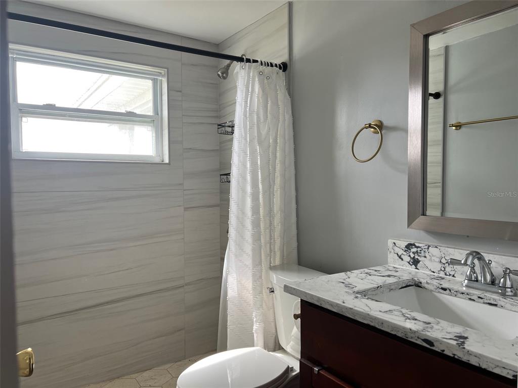 5046 Victoria Lane Holiday, FL 34690 - Photo 10 of 24 a bathroom with a granite countertop sink toilet and shower