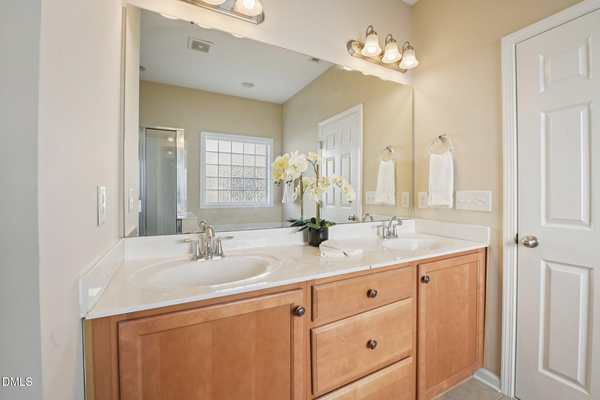11 Hidden Ridge Court Durham, NC 27707 - Photo 18 of 30 a bathroom with a double vanity sink and a mirror