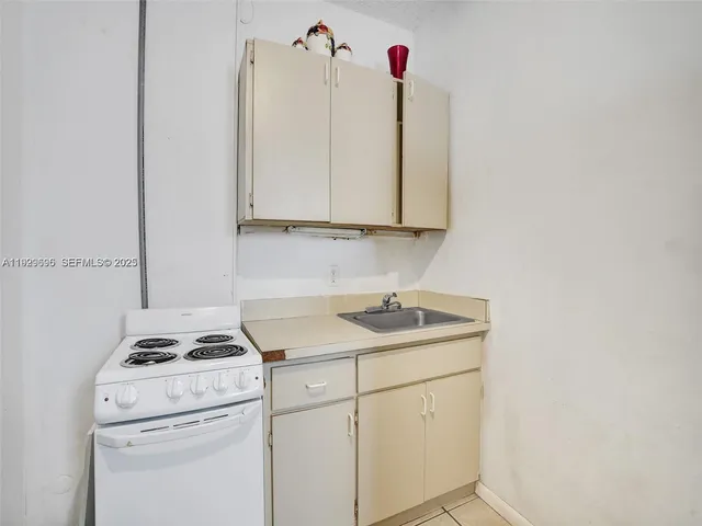 a kitchen with a sink cabinets and white appliances