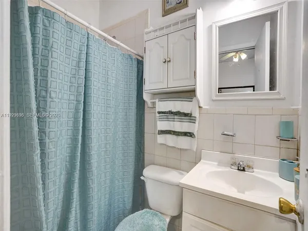 a bathroom with a sink a toilet and shower curtain