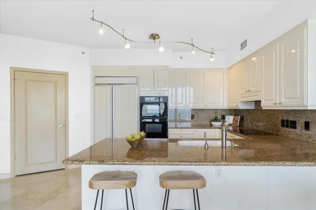 a kitchen with kitchen island granite countertop a counter top space cabinets and stainless steel appliances