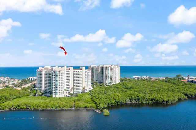 a front view of a building with lake view and a garden