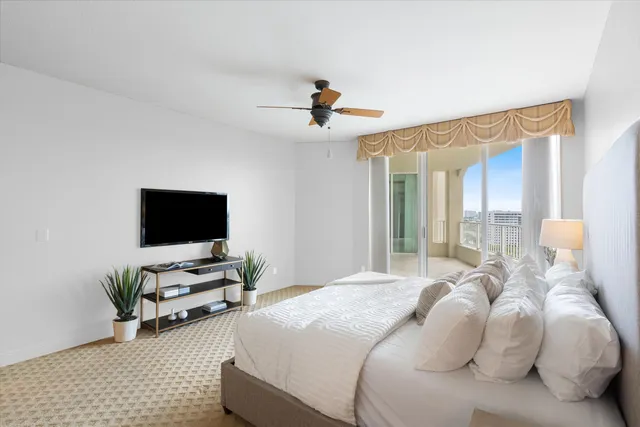 a bedroom with bed tv and window