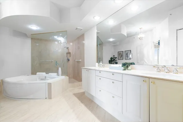 a bathroom with a sink double vanity mirror and a bathtub