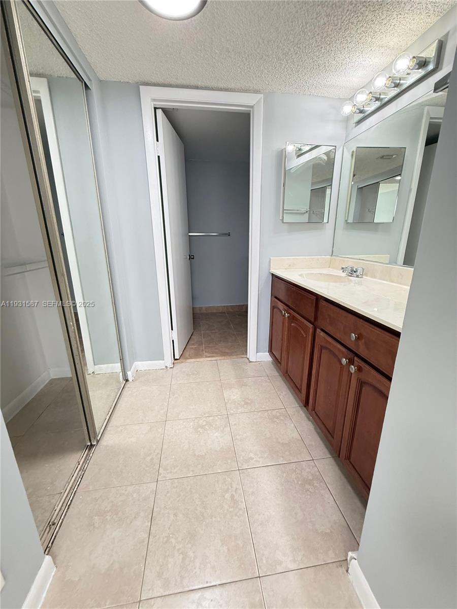 9855 Westview Drive, Unit 711 Coral Springs, FL 33076 - Photo 12 of 12 a bathroom with a sink a mirror and a vanity