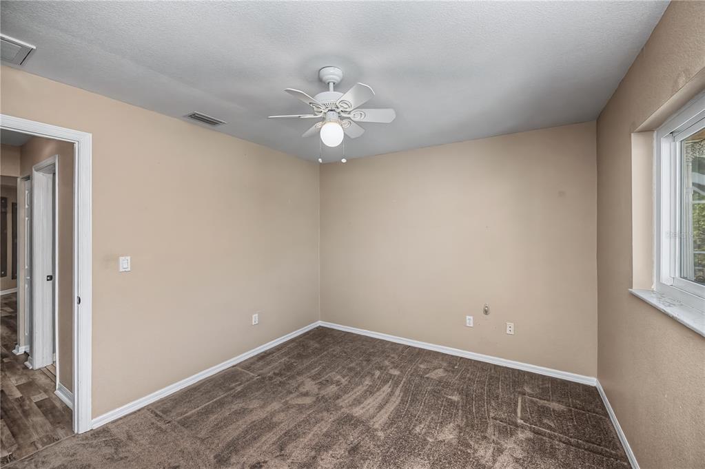 443 Fairmont Terrace Port Charlotte, FL 33954 - Photo 54 of 77 en empty room with windows and ceiling fan