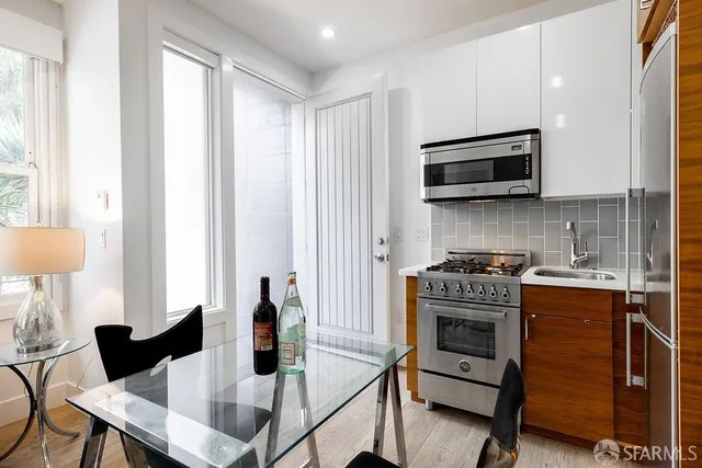 a kitchen with stainless steel appliances granite countertop a stove a sink and a microwave