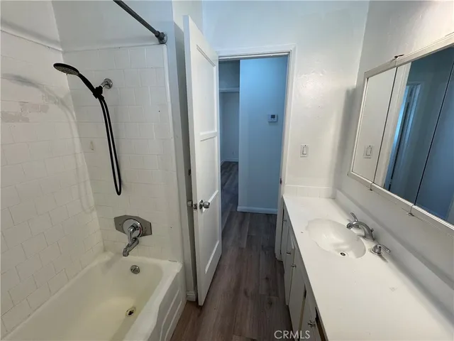 a bathroom with a tub sink and mirror