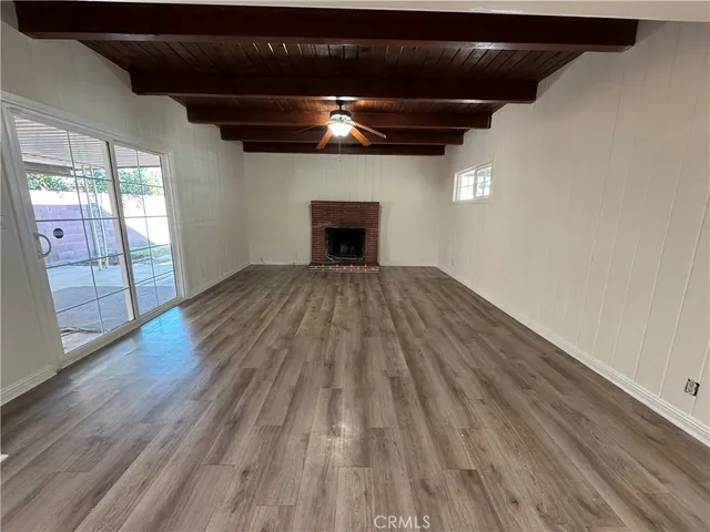 a view of empty room with wooden floor and fireplace
