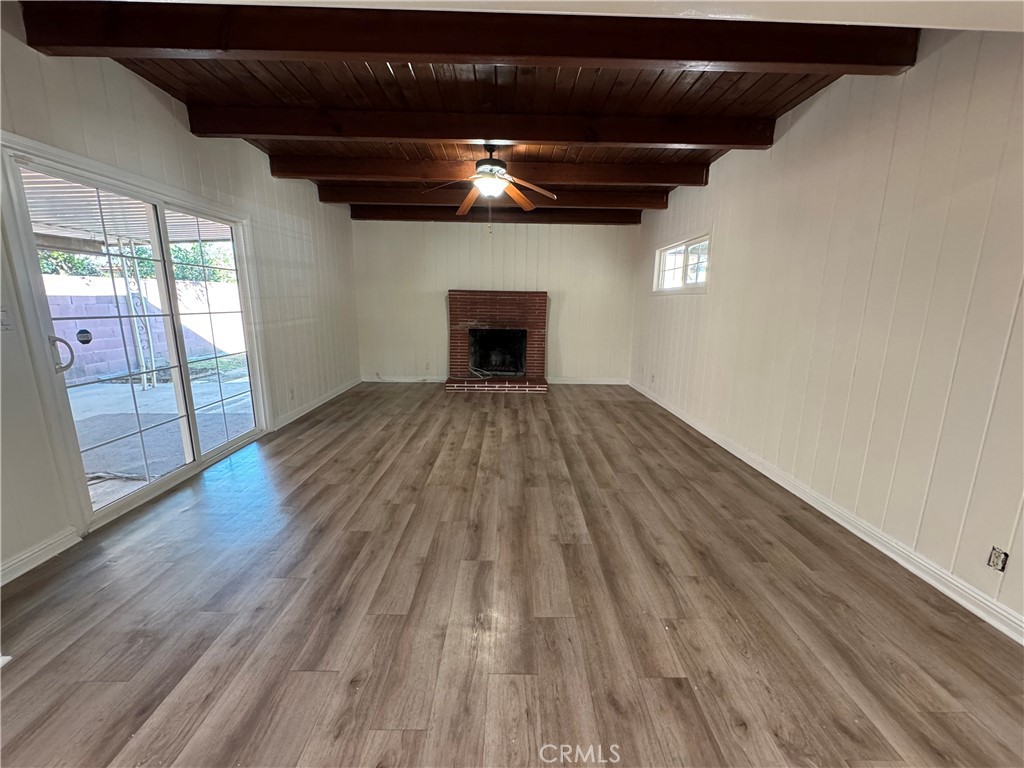 19427 Hart Street Reseda, CA 91335 - Photo 5 of 25 Large living room with brick fireplace and wood beam ceiling. Pretty paneling too.