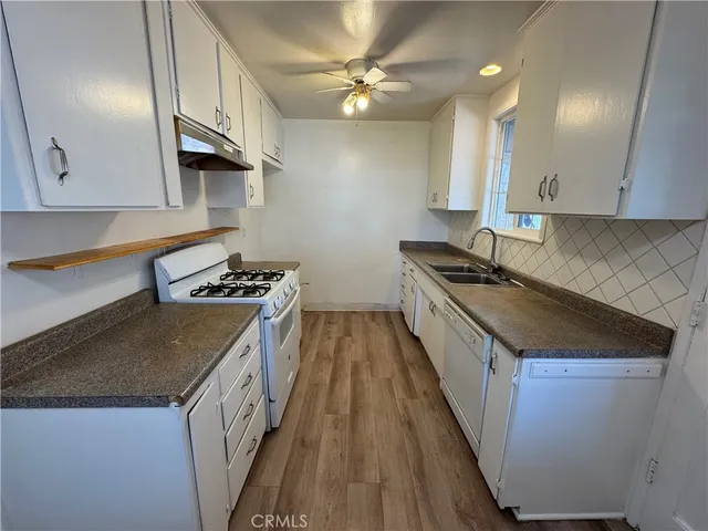 a kitchen with granite countertop a sink a counter top space and cabinets