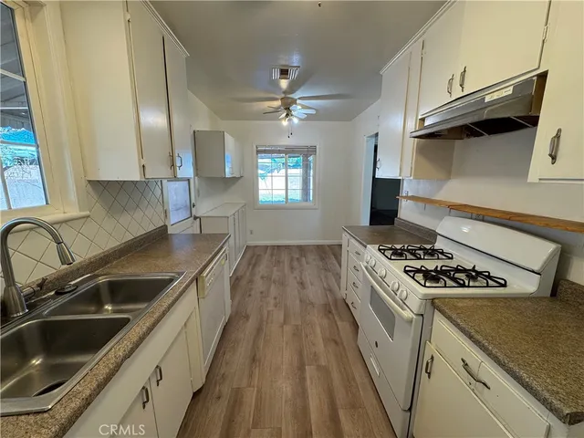 a kitchen with granite countertop a sink stainless steel appliances and cabinets