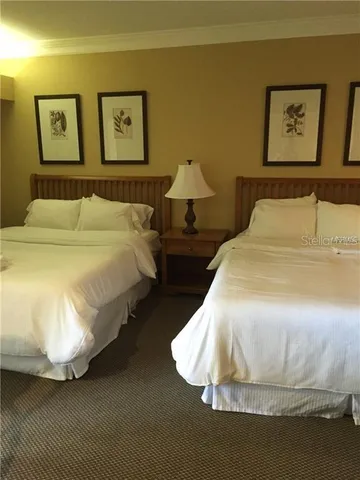 a spacious bedroom with a bed and painting on the wall