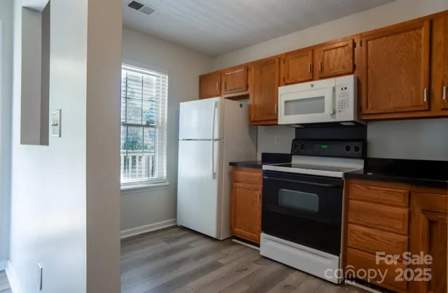 a kitchen with granite countertop a refrigerator stove and microwave