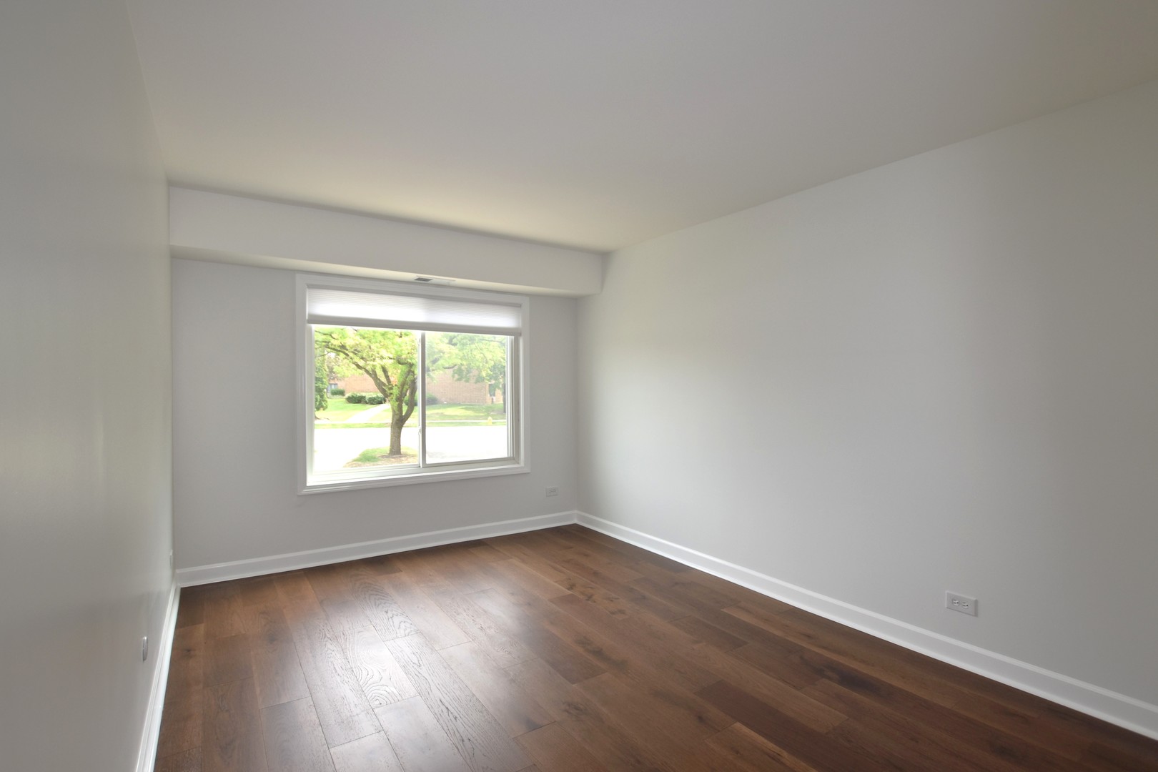 500 West Huntington Commons Road, Unit 157 Mount Prospect, IL 60056 - Photo 19 of 24 an empty room with wooden floor and windows