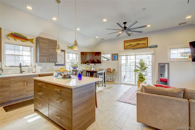 a living room with stainless steel appliances kitchen island furniture and a view of kitchen