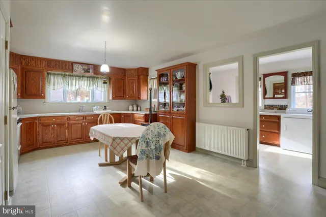 a kitchen with a table chairs refrigerator and cabinets