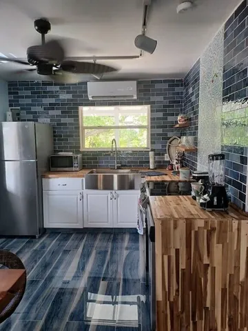 a kitchen with stainless steel appliances kitchen island granite countertop a stove and a refrigerator
