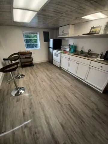 a vase with flowers on a table with wooden floor
