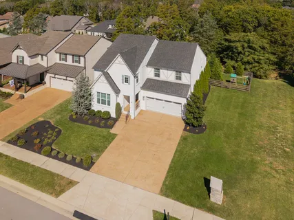 an aerial view of a house with a garden and lake view