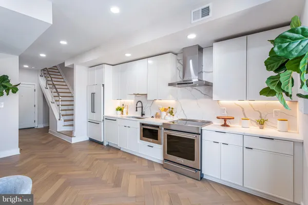 a kitchen with stainless steel appliances granite countertop a sink a stove and a refrigerator