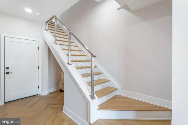 a view of staircase with wooden floor and white walls