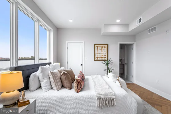 a bedroom with bed and a large window