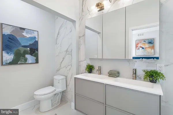 a bathroom with a granite countertop sink a toilet and a shower