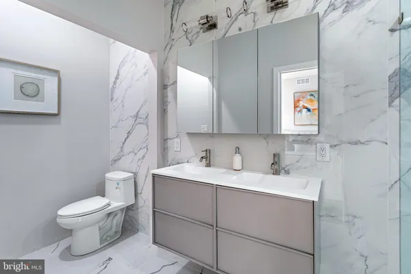 a bathroom with a toilet sink and mirror