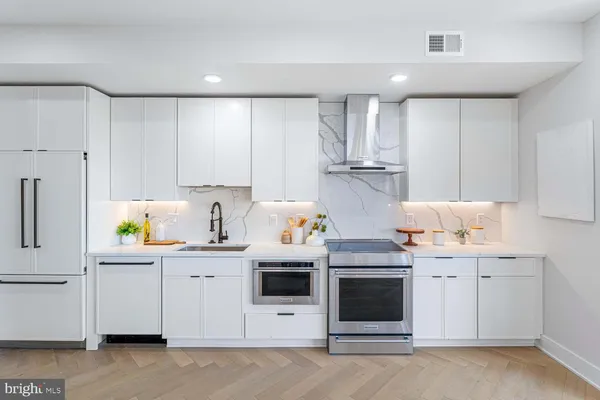 a kitchen with stainless steel appliances a stove a sink and a refrigerator