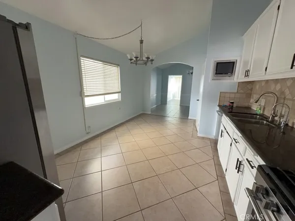 a large kitchen with a sink a stove top oven a counter space and cabinets