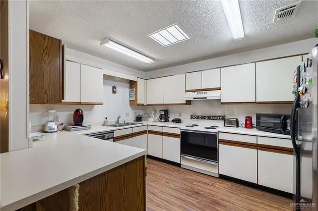 a kitchen with cabinets and stainless steel appliances