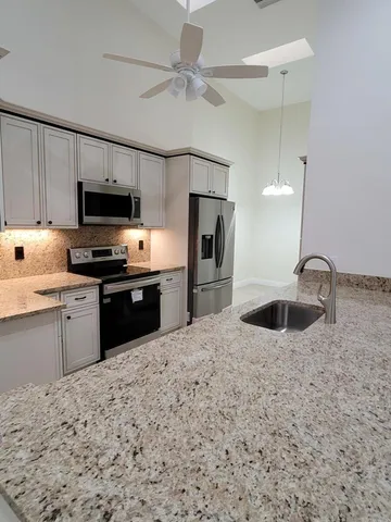 a kitchen with stainless steel appliances granite countertop a sink stove and refrigerator