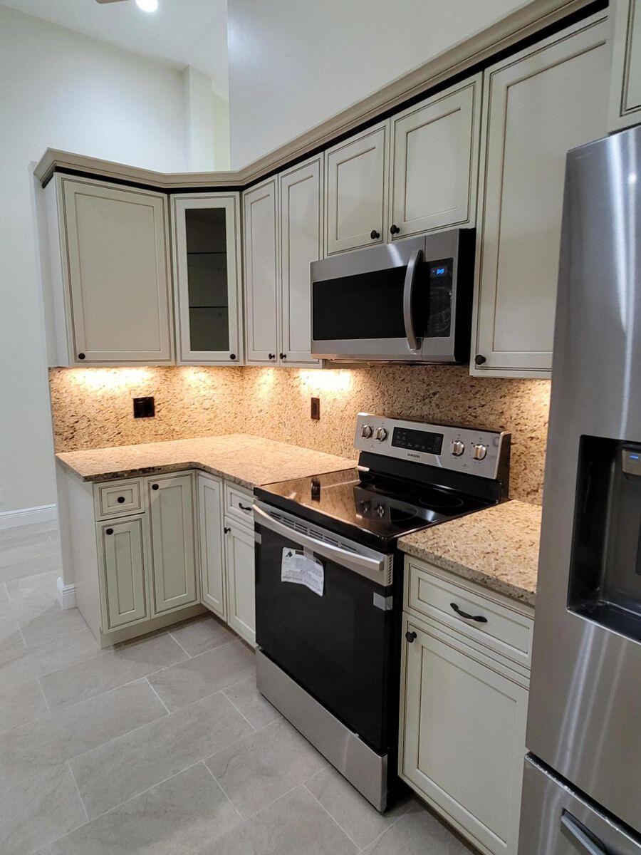 11000 Ladera Lane, Unit B Boca Raton, FL 33498 - Photo 11 of 29 a kitchen with stainless steel appliances granite countertop a sink and a stove