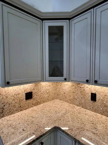 a close view of a sink a mirror and cabinets