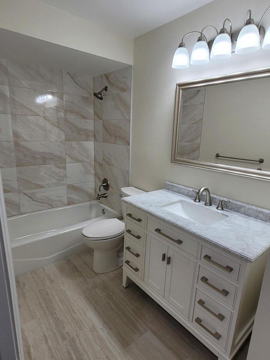 11000 Ladera Lane, Unit B Boca Raton, FL 33498 - Photo 26 of 29 a bathroom with a granite countertop sink a toilet and bathtub