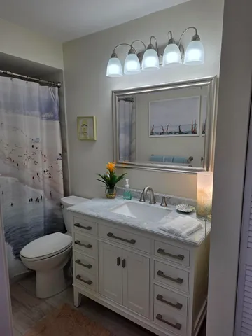 a bathroom with a granite countertop sink mirror and toilet
