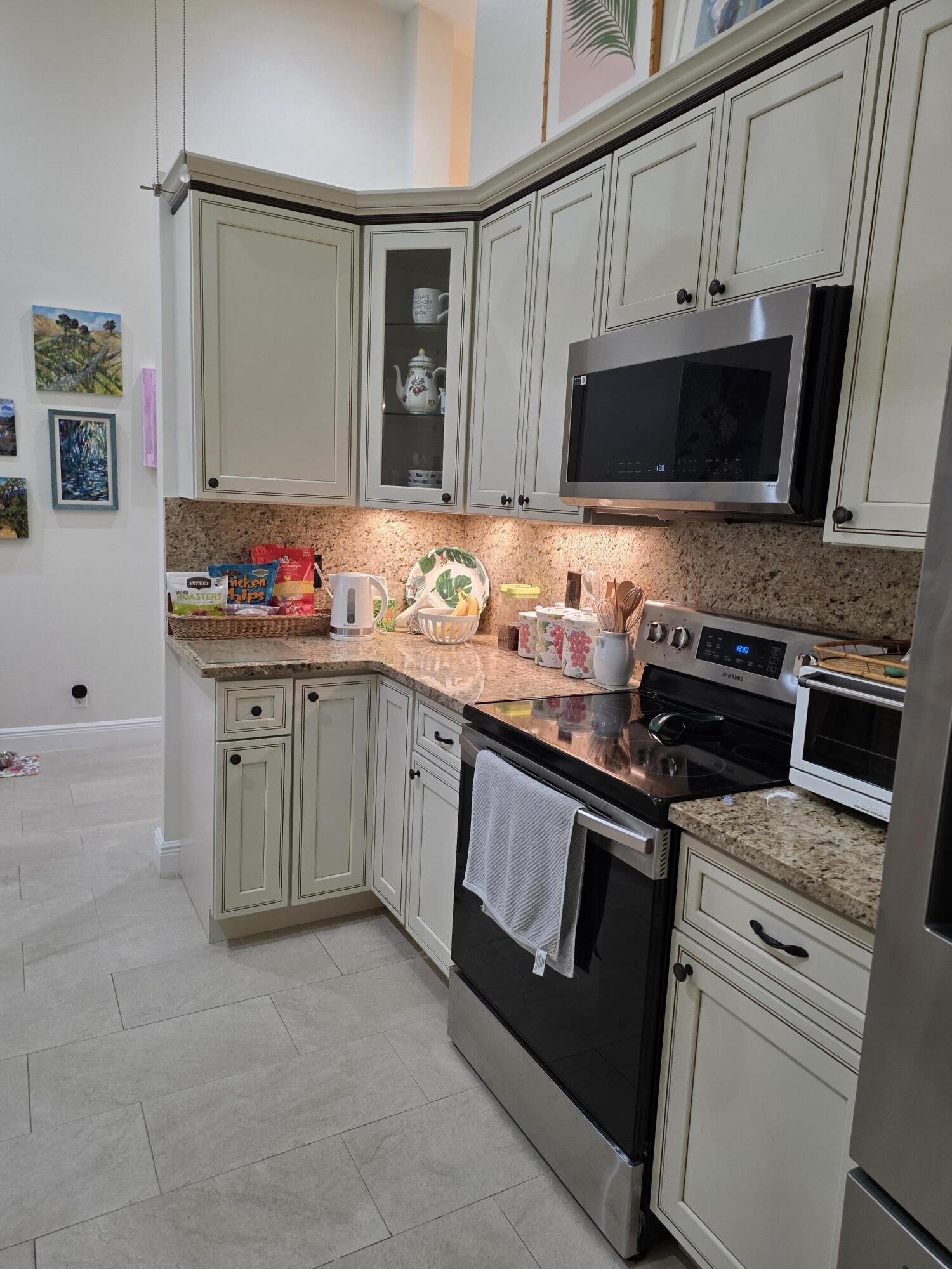 11000 Ladera Lane, Unit B Boca Raton, FL 33498 - Photo 5 of 29 a kitchen with stainless steel appliances a stove microwave and sink