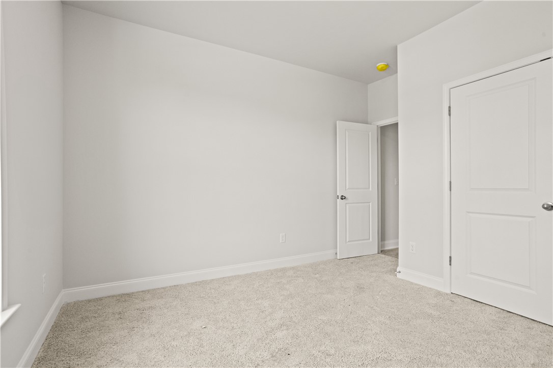 554 Hydrangea Street, Unit LOT 67 Seneca, SC 29678 - Photo 12 of 26 A spacious room offers comfortable carpet flooring and clean, freshly painted walls.