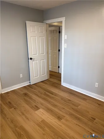 an empty room with wooden floor and door