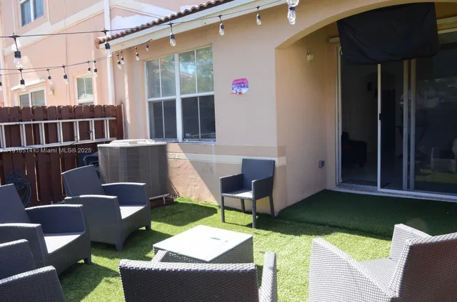 a view of a patio with couches chairs and a potted plant