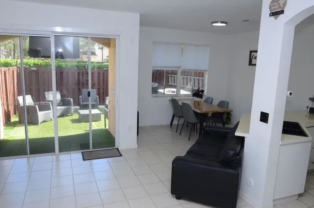 a dining room with furniture and a floor to ceiling window