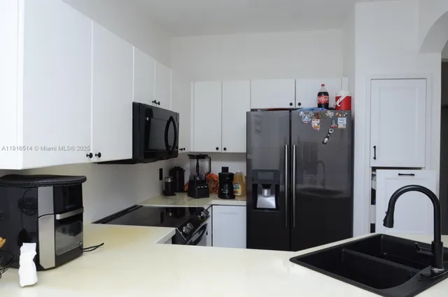 a kitchen with a refrigerator and a stove top oven